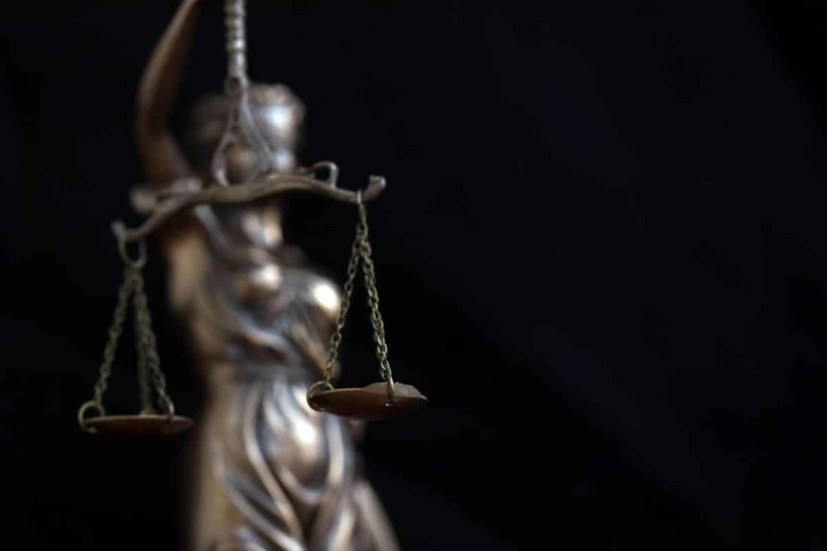 Bronze Lady Justice statue with balanced scales on a black background — Wisconsin OWI charges dismissed